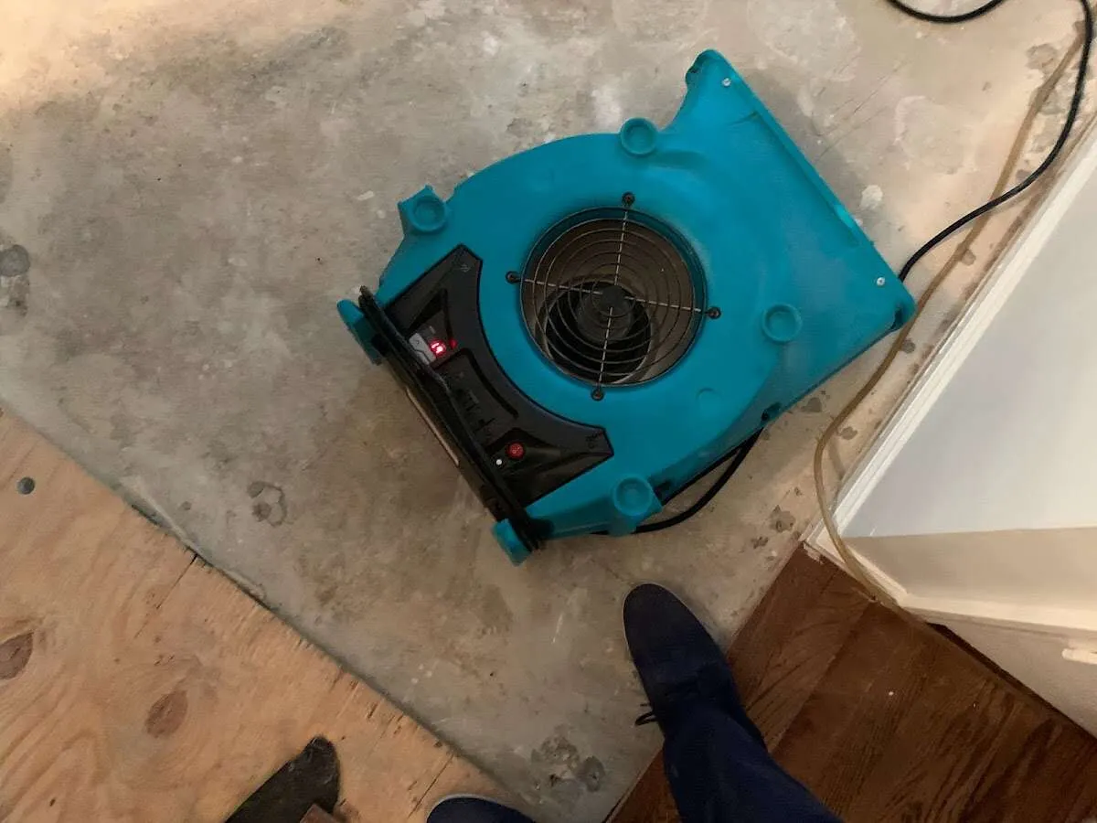 Air mover drying subfloor during Leak Detection & Repair in Bryan